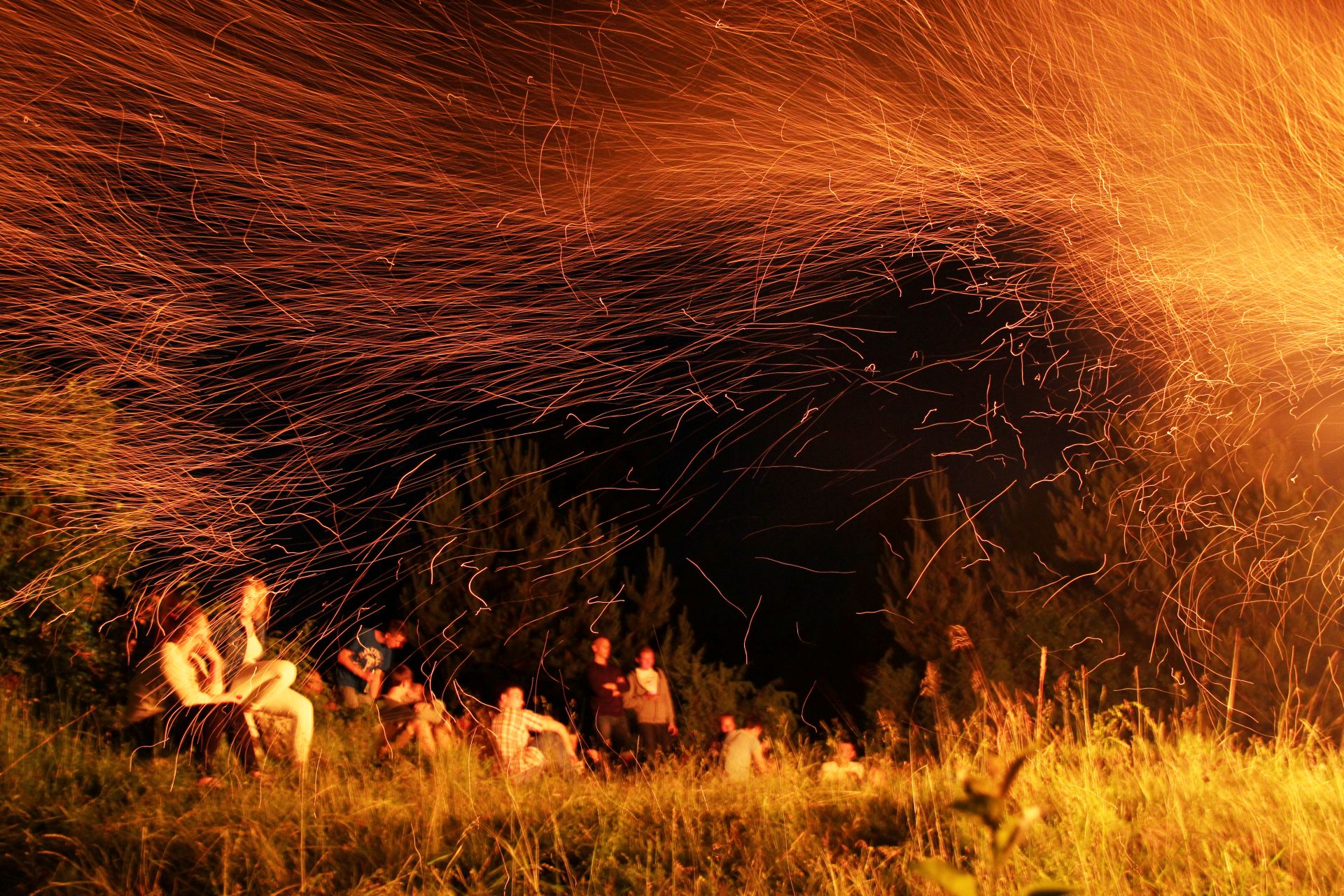 Zdjęcie grupy ludzi na polanie przy ognisku