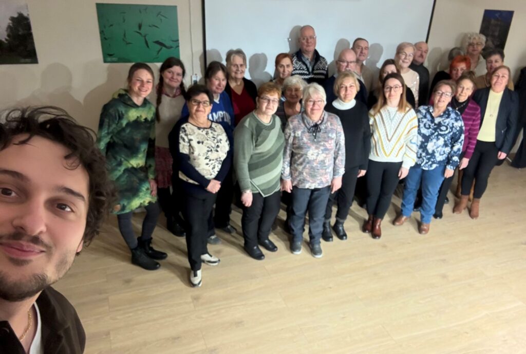 Na zdjęciu grupa chórzystów podczas warsztatów chóralnych prowadzonych przez Kamila Gojowego.