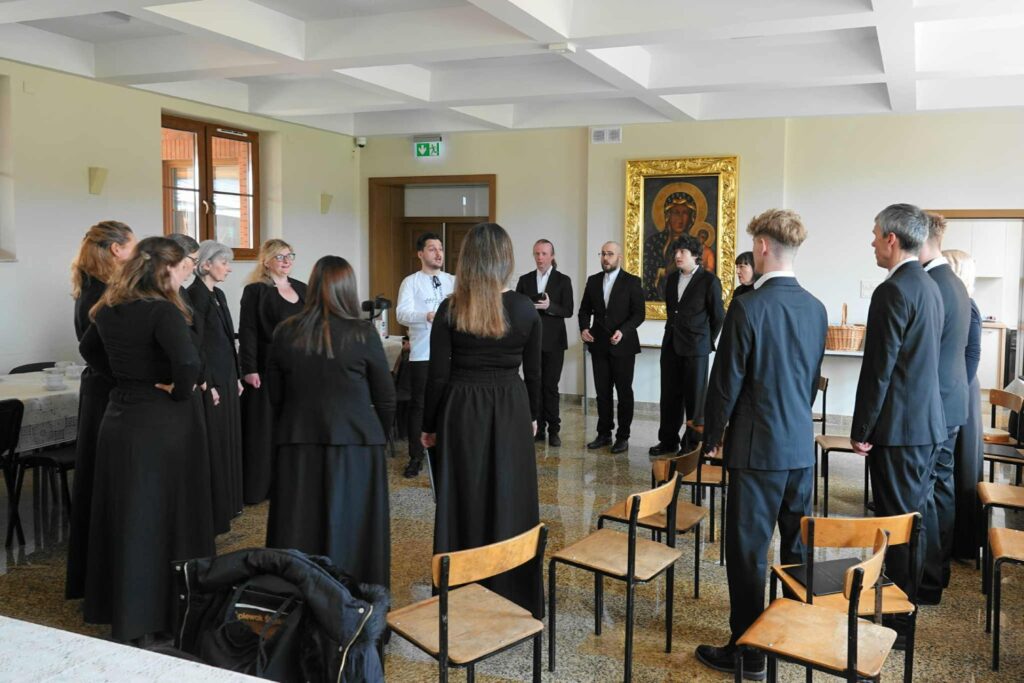 Na zdjęciu grupa chórzystów podczas warsztatów chóralnych prowadzonych przez Kamila Gojowego.