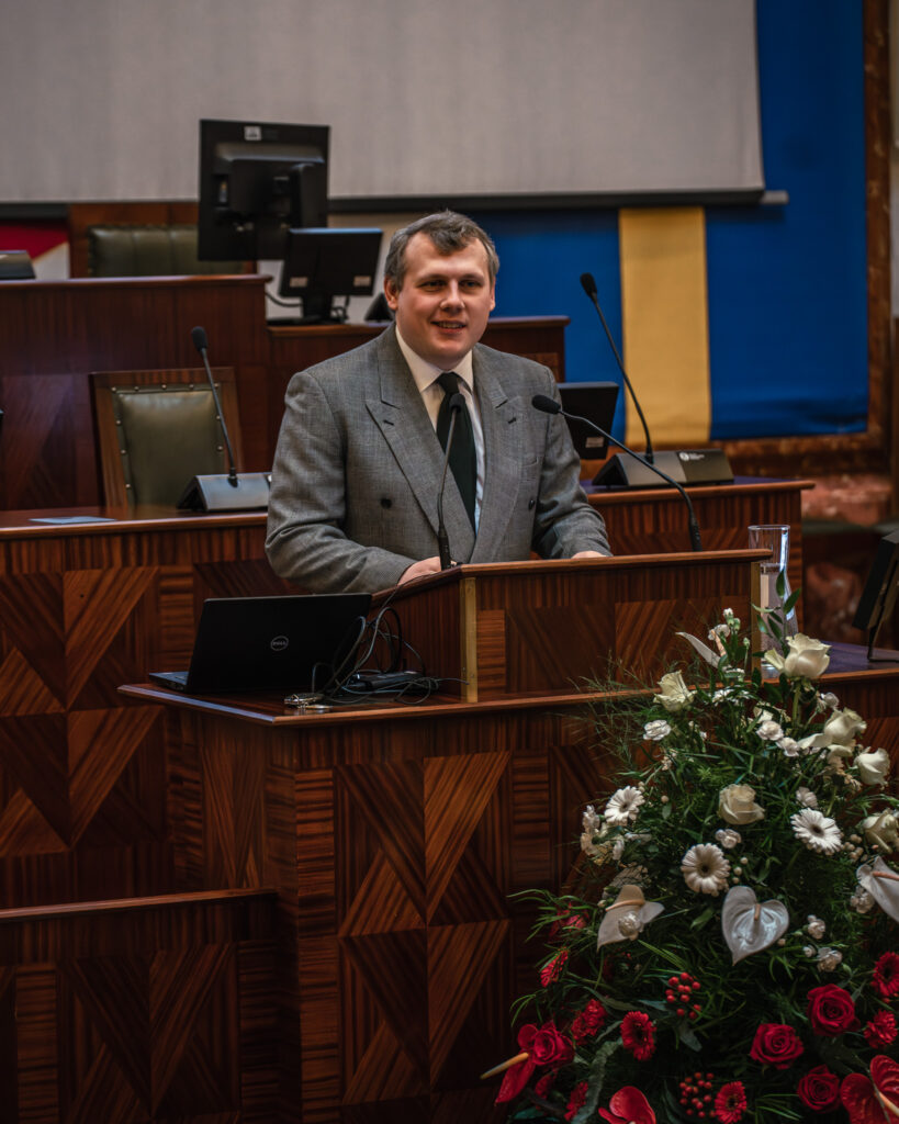 Mężczyzna stoi przy mównicy