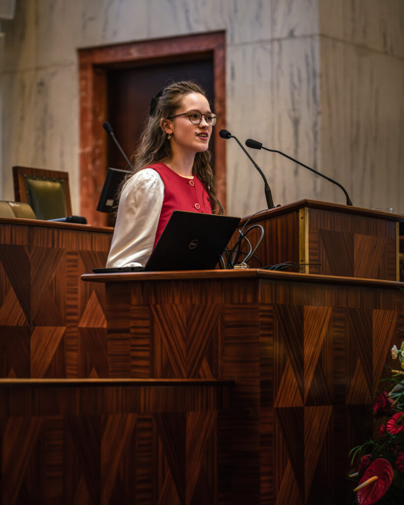 Młoda dziewczyna przemawia w sali Sejmu Śląskiego podczas konkursu
