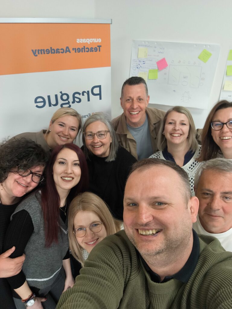 Grupa uśmiechniętych uczestników szkolenia pozuje do zdjęcia
